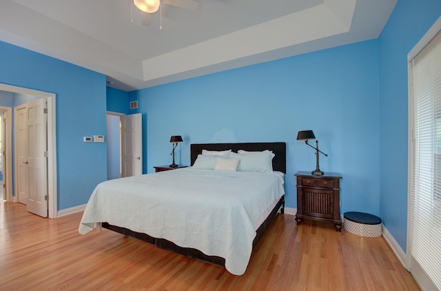 332 Stonemill Ln, Oswego, IL 60543 - bedroom featuring a raised ceiling, light wood-style floors, and ceiling fan