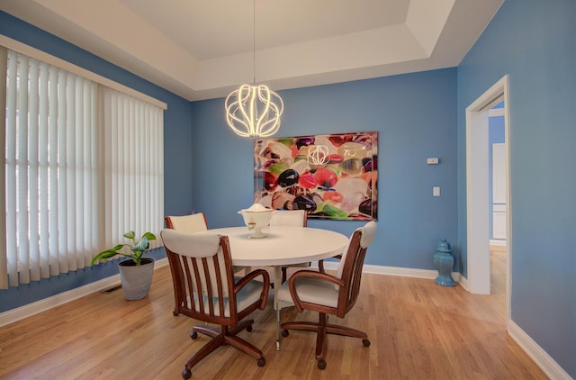 332 Stonemill Ln, Oswego, IL 60543 - dining room with light wood-style flooring, a chandelier, and a raised ceiling