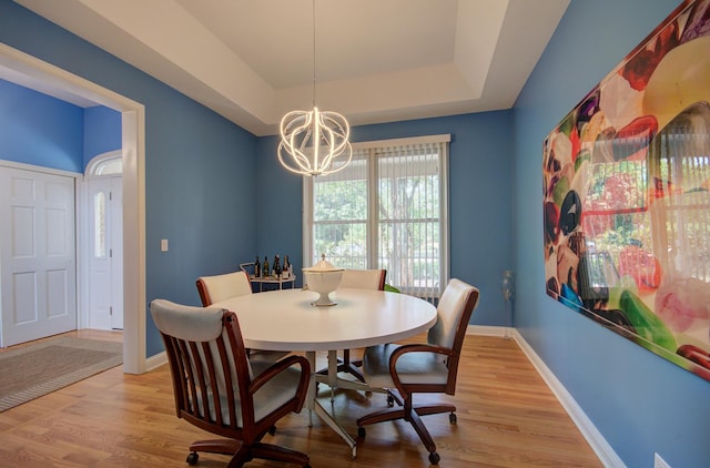 332 Stonemill Ln, Oswego, IL 60543 - dining space with a tray ceiling, a chandelier, and light wood-style floors