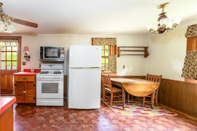 244 S Division St, Galena, IL 61036 - kitchen with white appliances, plenty of natural light, a chandelier, wainscoting, and a ceiling fan