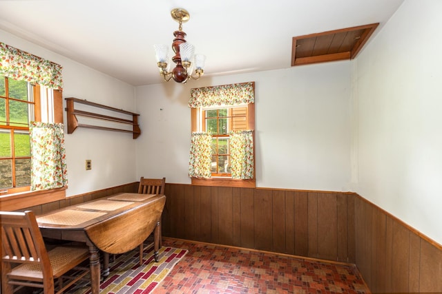 244 S Division St, Galena, IL 61036 - dining room with wainscoting, wood walls, a chandelier, and brick patterned floors