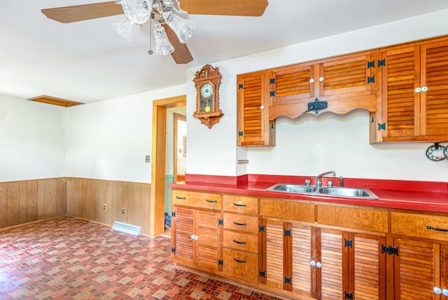 244 S Division St, Galena, IL 61036 - kitchen with a wainscoted wall, ceiling fan, wooden walls, and brick patterned flooring