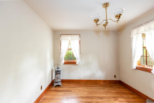 244 S Division St, Galena, IL 61036 - spare room with a chandelier and light wood-style flooring