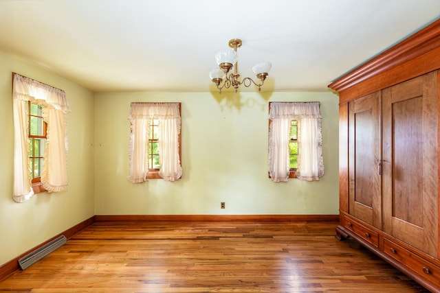 244 S Division St, Galena, IL 61036 - unfurnished room featuring wood finished floors and a chandelier