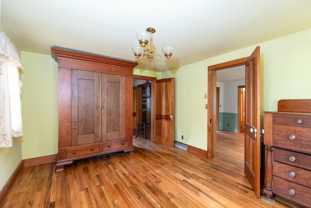 244 S Division St, Galena, IL 61036 - unfurnished bedroom featuring light wood finished floors and a chandelier