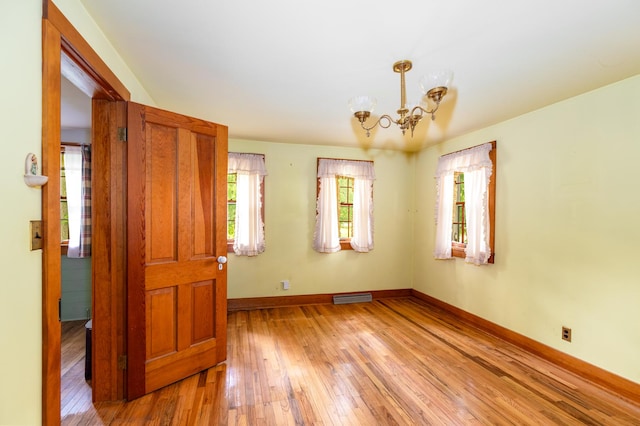 244 S Division St, Galena, IL 61036 - spare room featuring light wood-type flooring and a chandelier