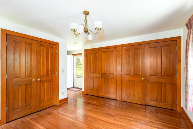 244 S Division St, Galena, IL 61036 - unfurnished bedroom with a chandelier, light wood-style flooring, and a closet