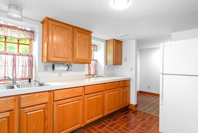 244 S Division St, Galena, IL 61036 - kitchen with freestanding refrigerator, light countertops, brick patterned flooring, and brown cabinetry