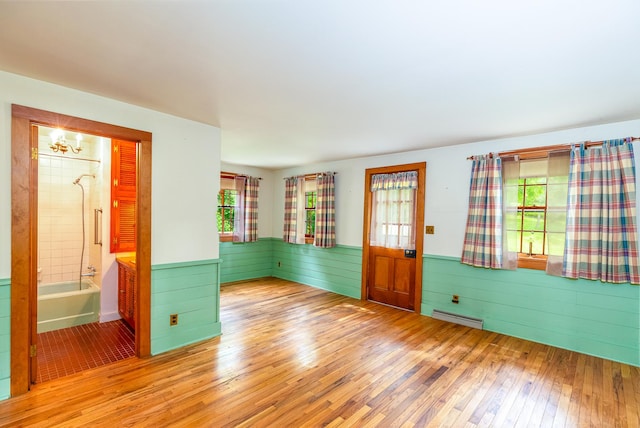 244 S Division St, Galena, IL 61036 - empty room with wood-type flooring, healthy amount of natural light, a wainscoted wall, a chandelier, and wood walls