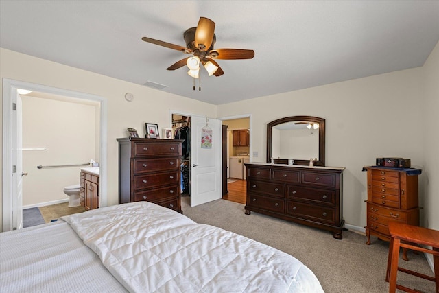 209A Evergreen St, Gifford, IL 61847 - bedroom with washing machine and clothes dryer, connected bathroom, a walk in closet, light carpet, and a ceiling fan