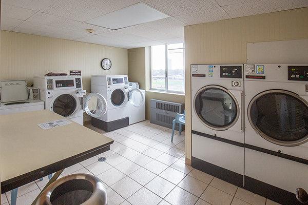 110 W Butterfield Rd Unit 405S, Elmhurst, IL 60126 - shared laundry room with separate washer and dryer, radiator heating unit, light tile patterned flooring, and wooden walls