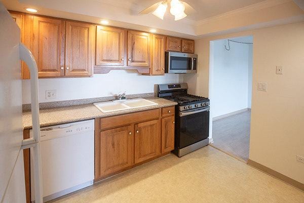 110 W Butterfield Rd Unit 405S, Elmhurst, IL 60126 - kitchen with stainless steel appliances, light countertops, brown cabinetry, crown molding, and recessed lighting