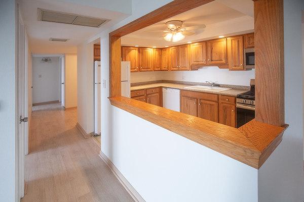 110 W Butterfield Rd Unit 405S, Elmhurst, IL 60126 - kitchen with stainless steel appliances, light wood-style floors, brown cabinetry, and light countertops