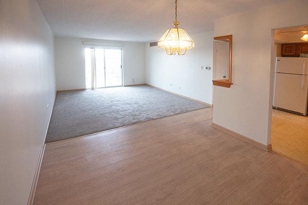 110 W Butterfield Rd Unit 405S, Elmhurst, IL 60126 - empty room with a chandelier, light wood finished floors, and light colored carpet