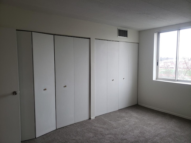110 W Butterfield Rd Unit 405S, Elmhurst, IL 60126 - unfurnished bedroom featuring two closets and carpet flooring