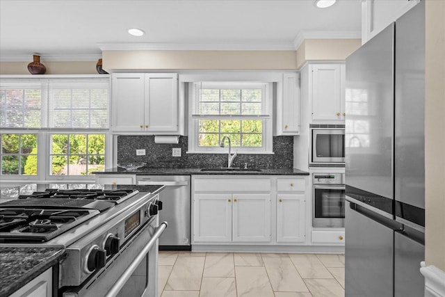 912 Morningside Dr, Lake Forest, IL 60045 - kitchen featuring appliances with stainless steel finishes, crown molding, white cabinetry, dark stone counters, and decorative backsplash