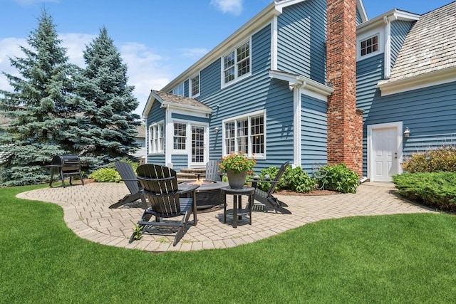 590 Oxford Ln, Lindenhurst, IL 60046 - back of house with a chimney, a patio area, a yard, and an outdoor fire pit