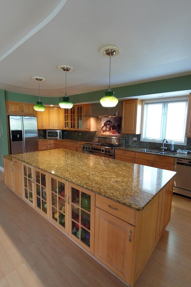 3533 N Natoma Ave, Chicago, IL 60634 - kitchen featuring appliances with stainless steel finishes, wall chimney exhaust hood, a spacious island, backsplash, and light wood-type flooring
