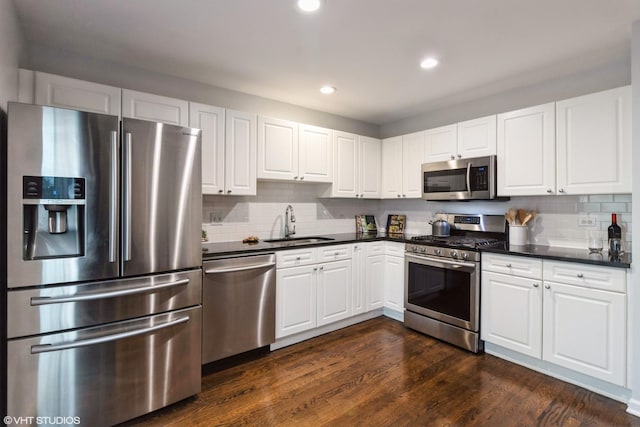 1487 N Clybourn Ave Unit B, Chicago, IL 60610 - kitchen featuring appliances with stainless steel finishes, dark countertops, white cabinets, and recessed lighting