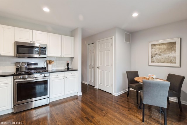 1487 N Clybourn Ave Unit B, Chicago, IL 60610 - kitchen featuring appliances with stainless steel finishes, dark countertops, decorative backsplash, dark wood-type flooring, and white cabinetry
