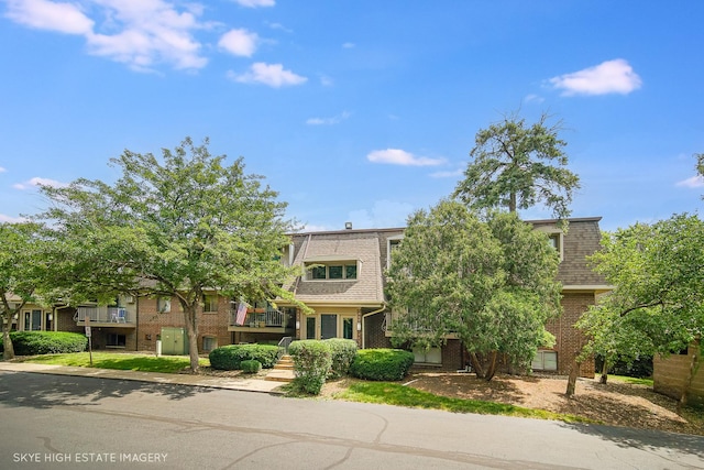 128 Bailey Rd Unit G, Naperville, IL 60565 - view of front of property with mansard roof, brick siding, and a shingled roof