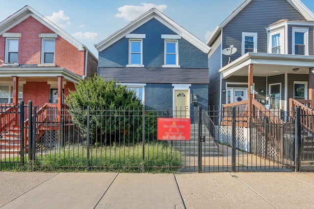 5048 W Superior St, Chicago, IL 60644 - view of front facade with covered porch, brick siding, and a fenced front yard