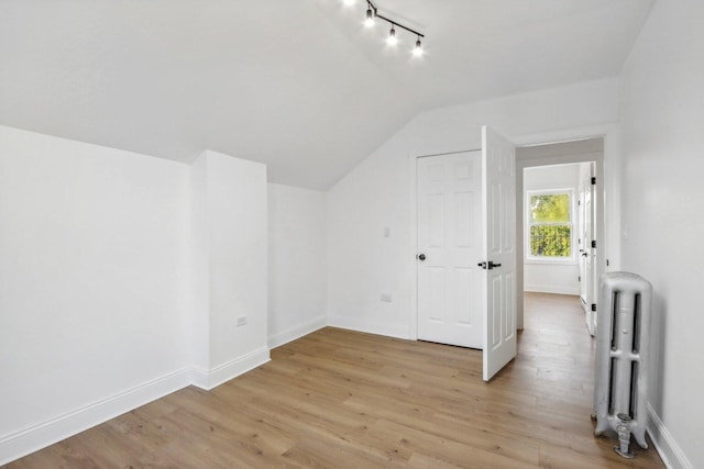 5048 W Superior St, Chicago, IL 60644 - additional living space featuring radiator heating unit, vaulted ceiling, and light wood finished floors