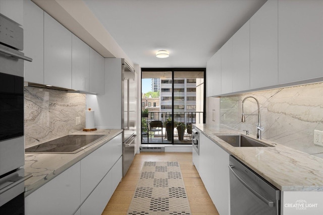 1410 N State Pkwy Unit 5B, Chicago, IL 60610 - kitchen with appliances with stainless steel finishes, expansive windows, tasteful backsplash, white cabinetry, and light stone counters