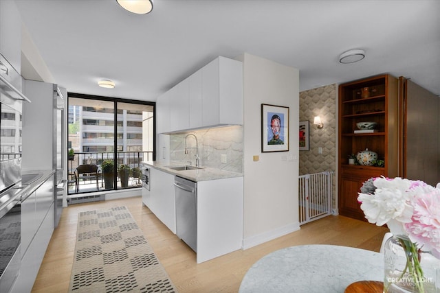 1410 N State Pkwy Unit 5B, Chicago, IL 60610 - kitchen featuring light countertops, modern cabinets, dishwasher, white cabinetry, and light wood-style floors