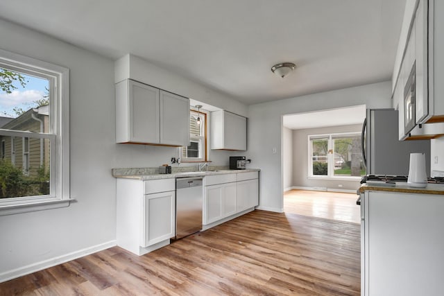 730 E 156th St, South Holland, IL 60473 - kitchen featuring stainless steel appliances, light wood finished floors, light countertops, and white cabinets