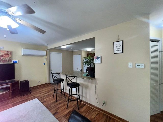 1313 Loral Ave, Joliet, IL 60435 - kitchen featuring an AC wall unit, wood finished floors, ceiling fan, and a kitchen bar
