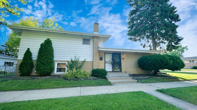 619 E 152nd St, Dolton, IL 60419 - tri-level home featuring brick siding, a chimney, and a front yard