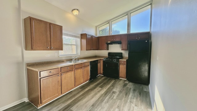 619 E 152nd St, Dolton, IL 60419 - kitchen featuring black appliances, wood finished floors, under cabinet range hood, and light countertops