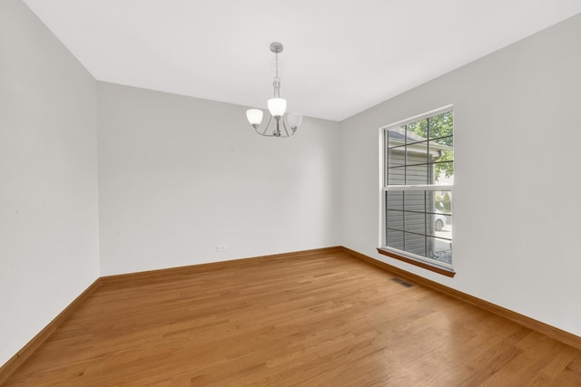 15 Harrison Ln, Streamwood, IL 60107 - spare room with a chandelier and light wood-type flooring