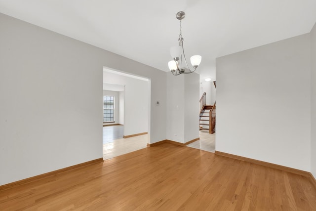 15 Harrison Ln, Streamwood, IL 60107 - spare room with stairs, a chandelier, and light wood-type flooring