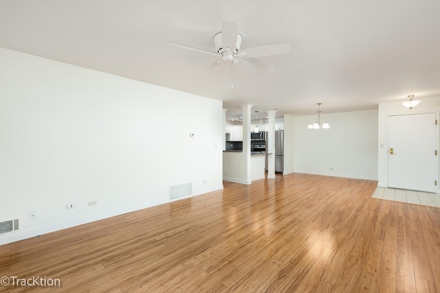 7515 Nantucket Dr Unit 202, Darien, IL 60561 - unfurnished living room featuring light wood-style floors, a chandelier, and a ceiling fan