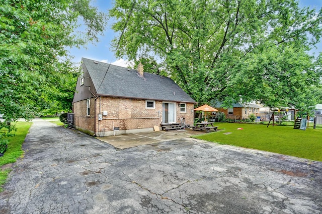 7912 S 85th Ave, Justice, IL 60458 - back of house featuring entry steps, brick siding, a chimney, a yard, and a shingled roof