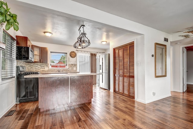 7912 S 85th Ave, Justice, IL 60458 - kitchen with stainless steel appliances, light countertops, a kitchen island, dark wood-style floors, and decorative backsplash