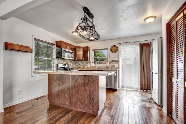 7912 S 85th Ave, Justice, IL 60458 - kitchen featuring stainless steel appliances, light countertops, dark wood-style flooring, tasteful backsplash, and decorative light fixtures