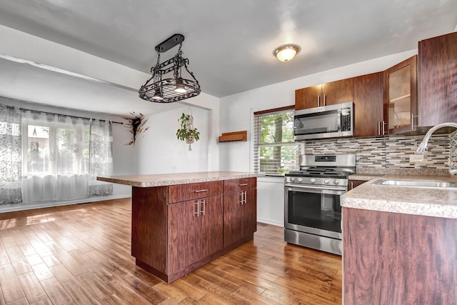 7912 S 85th Ave, Justice, IL 60458 - kitchen with stainless steel appliances, light wood finished floors, light countertops, tasteful backsplash, and a kitchen island