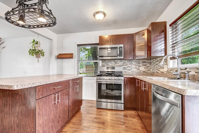 7912 S 85th Ave, Justice, IL 60458 - kitchen featuring appliances with stainless steel finishes, light wood-type flooring, backsplash, light countertops, and healthy amount of natural light