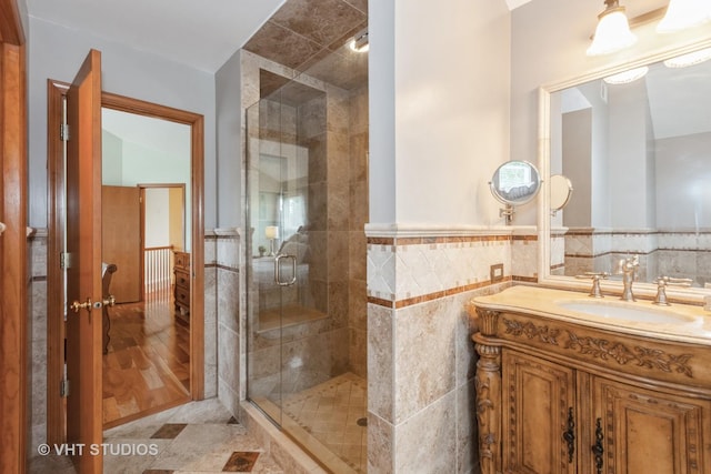 2578 Crestview Dr, Aurora, IL 60502 - bathroom featuring vanity, a shower stall, tile walls, and a wainscoted wall