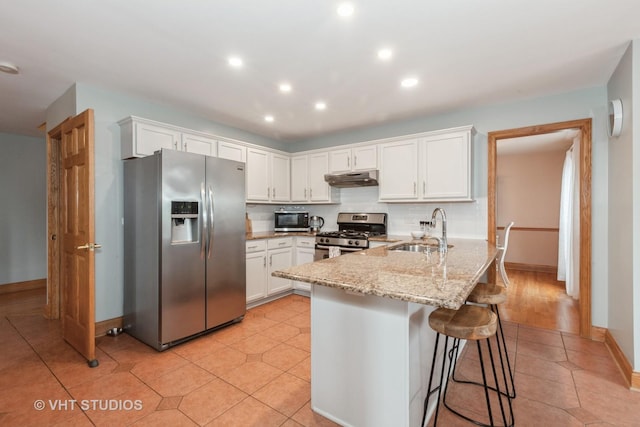 2578 Crestview Dr, Aurora, IL 60502 - kitchen featuring stainless steel appliances, under cabinet range hood, white cabinetry, a breakfast bar, and a peninsula