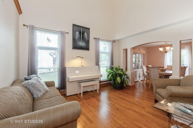 2578 Crestview Dr, Aurora, IL 60502 - living area with arched walkways, a chandelier, light wood-type flooring, and healthy amount of natural light