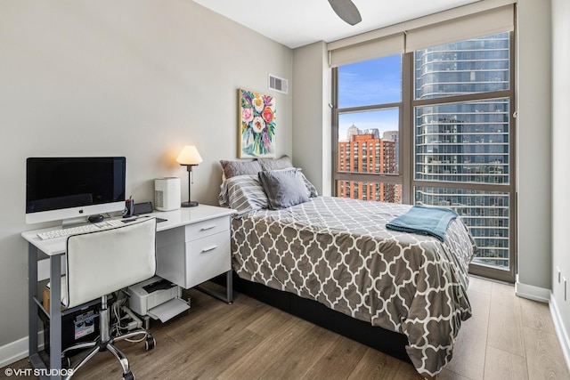 1101 S State St Unit 2202, Chicago, IL 60605 - bedroom featuring a wall of windows, wood finished floors, a desk, a view of city, and ceiling fan