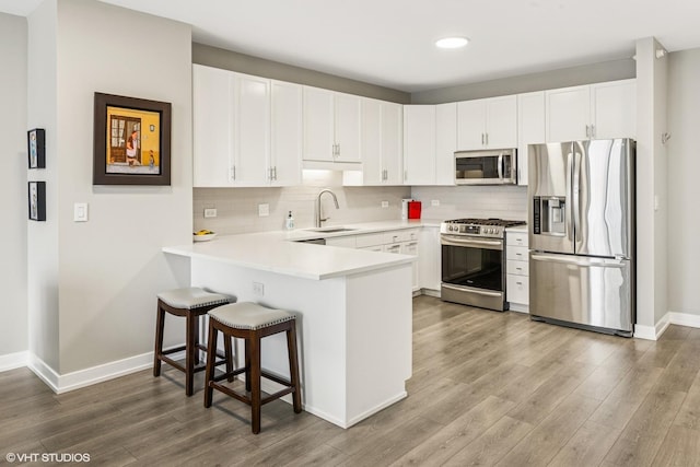 1101 S State St Unit 2202, Chicago, IL 60605 - kitchen with stainless steel appliances, a peninsula, wood finished floors, a breakfast bar, and recessed lighting