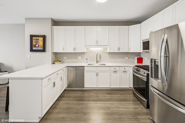 1101 S State St Unit 2202, Chicago, IL 60605 - kitchen featuring appliances with stainless steel finishes, a peninsula, wood finished floors, and white cabinetry