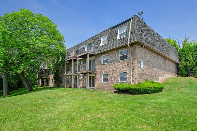 10130 S 84th Ter Unit 11107, Palos Hills, IL 60465 - back of house with a lawn, brick siding, mansard roof, and a balcony