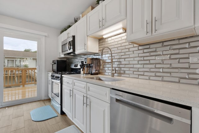 1669 W Bayside Ct, Hoffman Estates, IL 60192 - kitchen featuring appliances with stainless steel finishes, white cabinets, tasteful backsplash, and light stone countertops