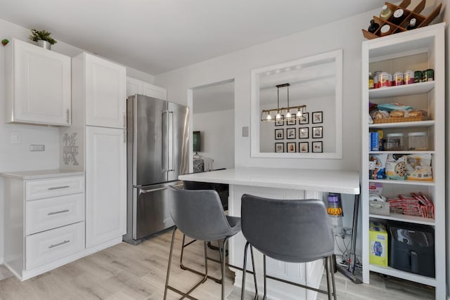 1669 W Bayside Ct, Hoffman Estates, IL 60192 - kitchen featuring high end fridge, light wood finished floors, a breakfast bar, white cabinets, and light countertops
